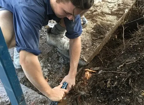 Experienced plumber inspecting underground pipes