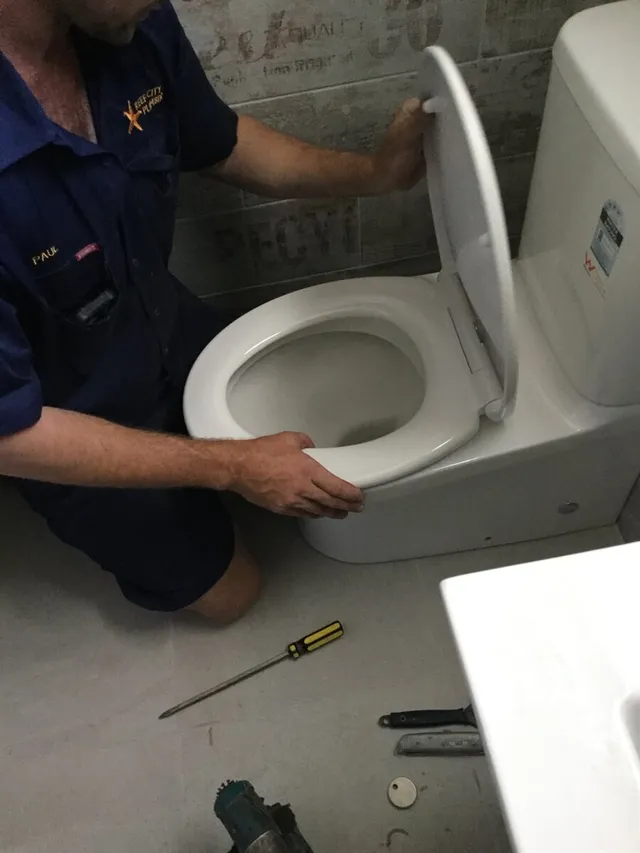 Plumber installing toilet in Gladstone